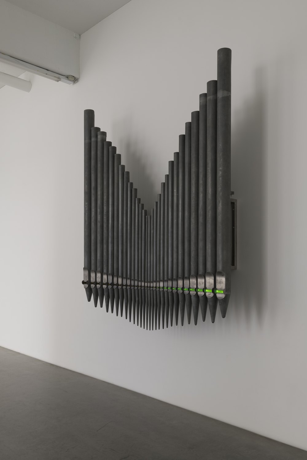 Jeremy Shaw Half-Life of Grace (1958), 2026 28 decommissioned zinc-based metal alloy church organ pipes, hand-blown uranium glass, ultra violet (UV) lights, electronic circuitry, transducer speakers, audio, stainless steel 300 x 255 x 58 cm